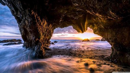 Stunning Coastal Sunset Through Rock Archway wallpaper