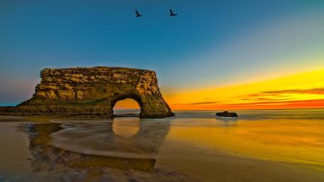 Serene Sunset Over Coastal Arch Formation wallpaper