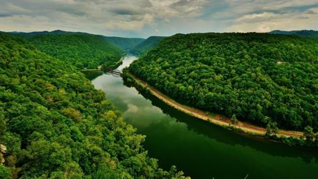 Tranquil River Surrounded by Lush Greenery wallpaper