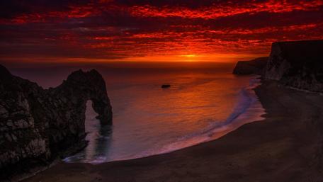 Fiery Sunset Over Serene Coastline wallpaper