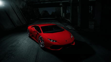 Sleek Red Supercar in a Dark Setting wallpaper