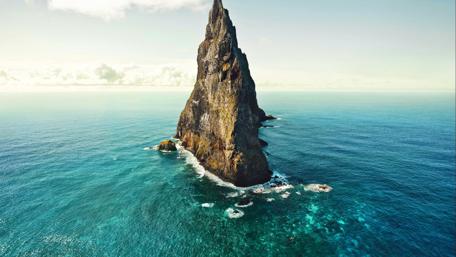 Majestic Oceanic Peak Rising Above The Waves wallpaper