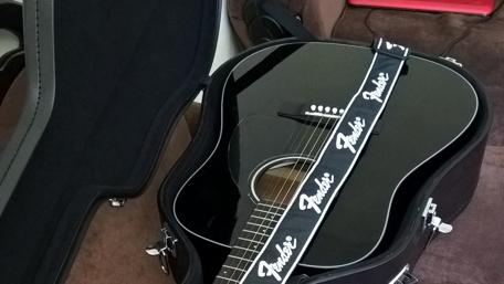 Elegant Black Fender Acoustic Displayed in Hardcase wallpaper