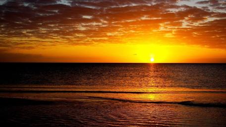 Breathtaking Sunset Over Tranquil Ocean Waves wallpaper