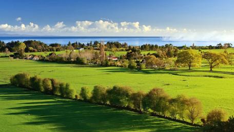 Serene Coastal Landscape with Lush Green Fields wallpaper