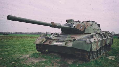 Modern Tank on Alert in Tranquil Field wallpaper