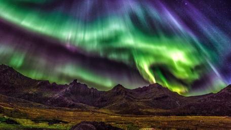 Majestic Aurora Borealis Over Serene Mountains wallpaper