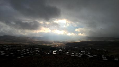 Dramatic Sky Over Serene Village Scene wallpaper