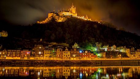 Illuminated Castle Overlooking River Town wallpaper