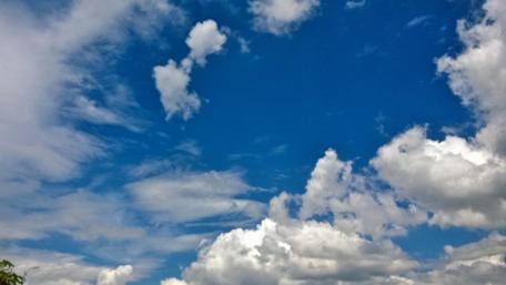 Vibrant Sky with Fluffy Clouds Brightening Daylight wallpaper