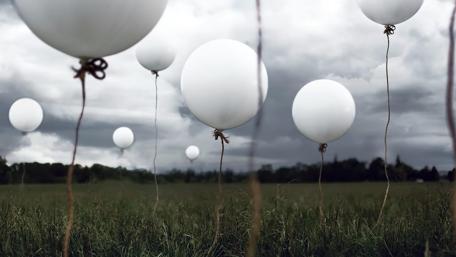Dreamy Balloons Over a Green Field wallpaper