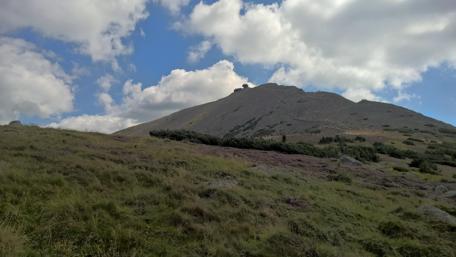 Serene Mountain Landscape Under Blue Skies wallpaper