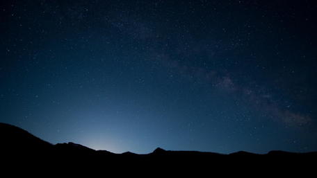 Starry Night Sky Over Mountain Peaks wallpaper