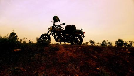 Classic Motorcycle Silhouette Against a Sunset Sky wallpaper