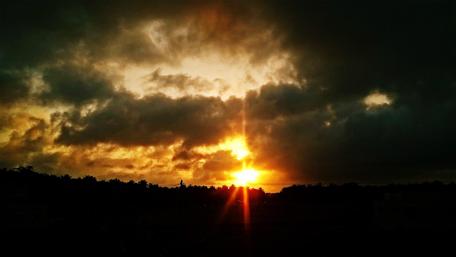 Golden Sunset Through Dramatic Clouds wallpaper