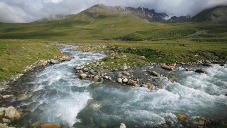 Majestic River Flowing Through Verdant Mountainscape wallpaper
