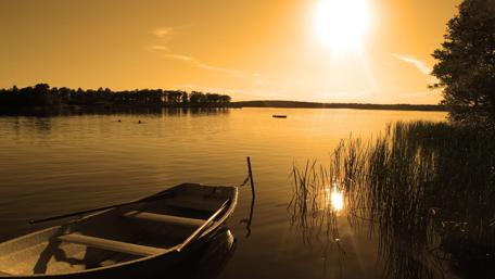 Golden Sunset Over Calm Waters with a Boat wallpaper