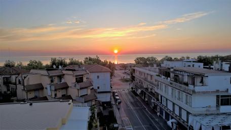 Radiant Sunrise Over Coastal Town wallpaper