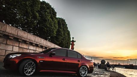 Sleek Crimson Car Against Serene Sunset Sky wallpaper