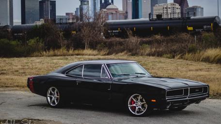 Classic Black Dodge Charger Against Urban Skyline wallpaper