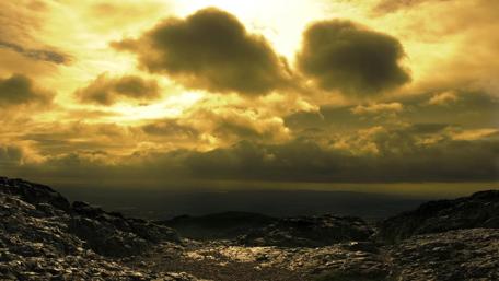 Golden Clouds Over Rocky Landscape wallpaper