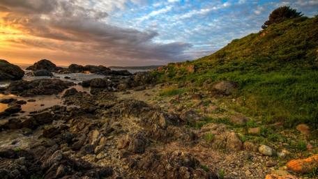 Serene Coastal Sunset Over Rocky Shoreline wallpaper