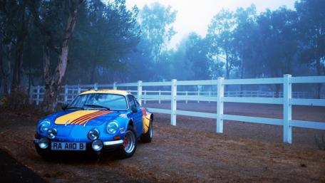 Vintage Sports Car Amidst Foggy Landscape wallpaper