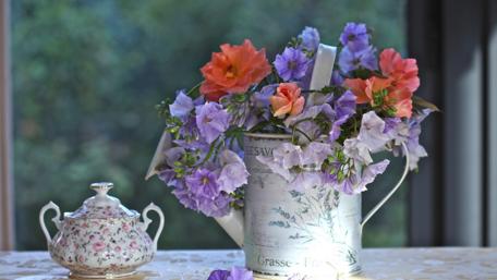 Charming Floral Arrangement in a Vintage Watering Can wallpaper