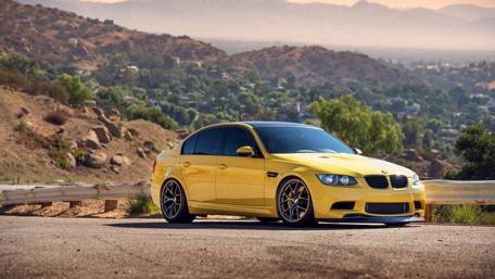 Vibrant Yellow BMW Against Scenic Landscape wallpaper