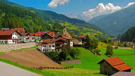 Tranquil Alpine Village Amidst Majestic Mountains wallpaper
