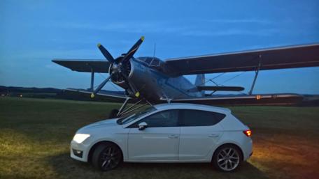 Vintage Plane and Modern Car Under Twilight Sky wallpaper