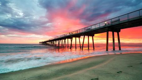 Serene Sunset Over Tranquil Beach Pier wallpaper