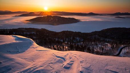 Serenity of a Winter Sunrise Over Frozen Landscape wallpaper