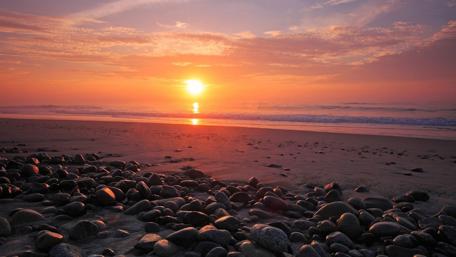 Tranquil Sunset Over Seashore Stones wallpaper