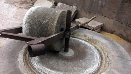 Rustic Grinding Stone in Old Workshop Setting wallpaper