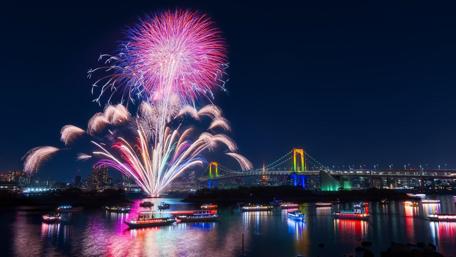 Vibrant Fireworks Over a Cityscape at Night wallpaper