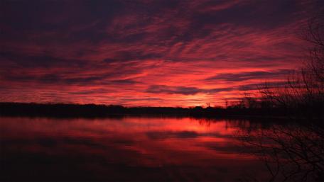 Fiery Sunset Over Tranquil Lake Reflection wallpaper