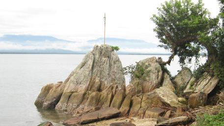 Serene Rocky Shoreline with Lush Greenery wallpaper