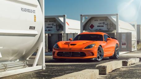 Sleek Orange Sports Car in Urban Setting wallpaper