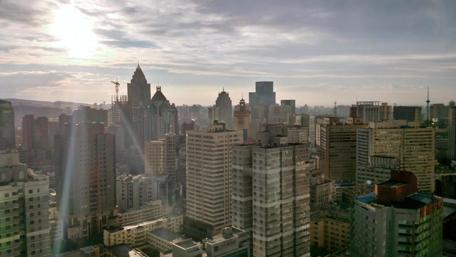 City Skyline at Dawn with Golden Sunlight wallpaper
