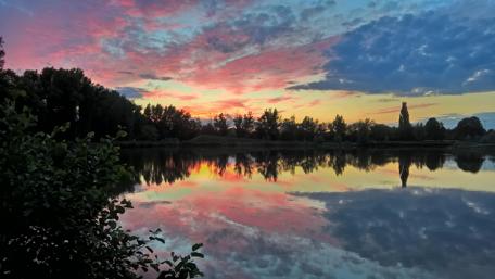 Serene Sunset Over Reflective Water Surface wallpaper