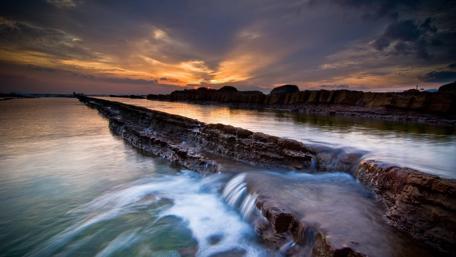 Serene Sunset Over Tranquil Waterfall wallpaper