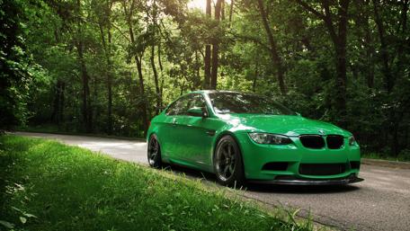 Vibrant Green BMW on a Forest Road wallpaper