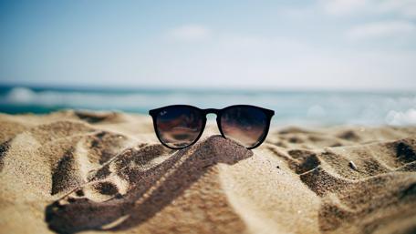 Chic Sunglasses on Sandy Beach Scene wallpaper