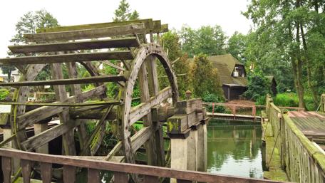 Rustic Water Wheel Amidst Lush Greenery wallpaper