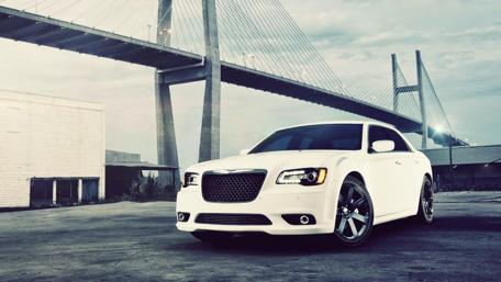Sleek White Car Under a Majestic Bridge wallpaper