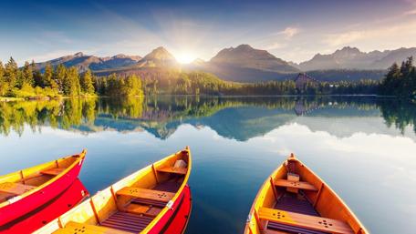Serene Lake at Sunrise with Colorful Boats wallpaper