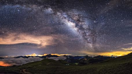 Starry Embrace Over Tranquil Mountains wallpaper