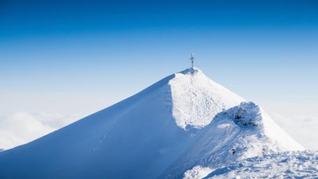 Majestic Snowcapped Mountain Peak Under Blue Sky wallpaper