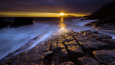 Golden Sunset Over Rocky Shoreline wallpaper